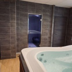 Salle bien être équipée d'un spa à débordement et d'un Hammam carrelé